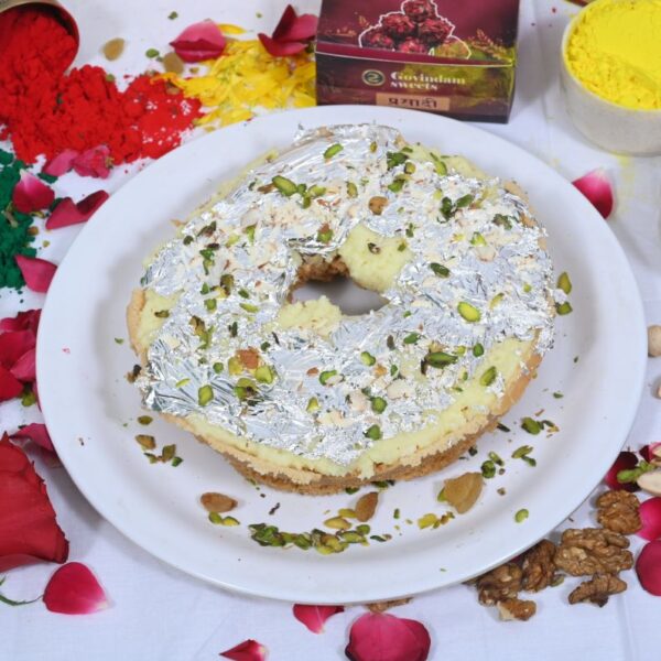 Close-up of Meetha Ghewar soaked in sugar syrup with almond and pistachio garnish