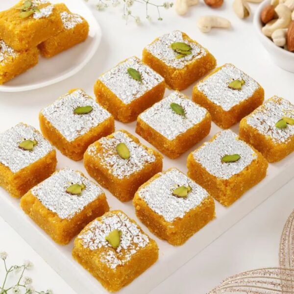 Close-up of Moong Dal Barfi with golden color and almond-pistachio topping